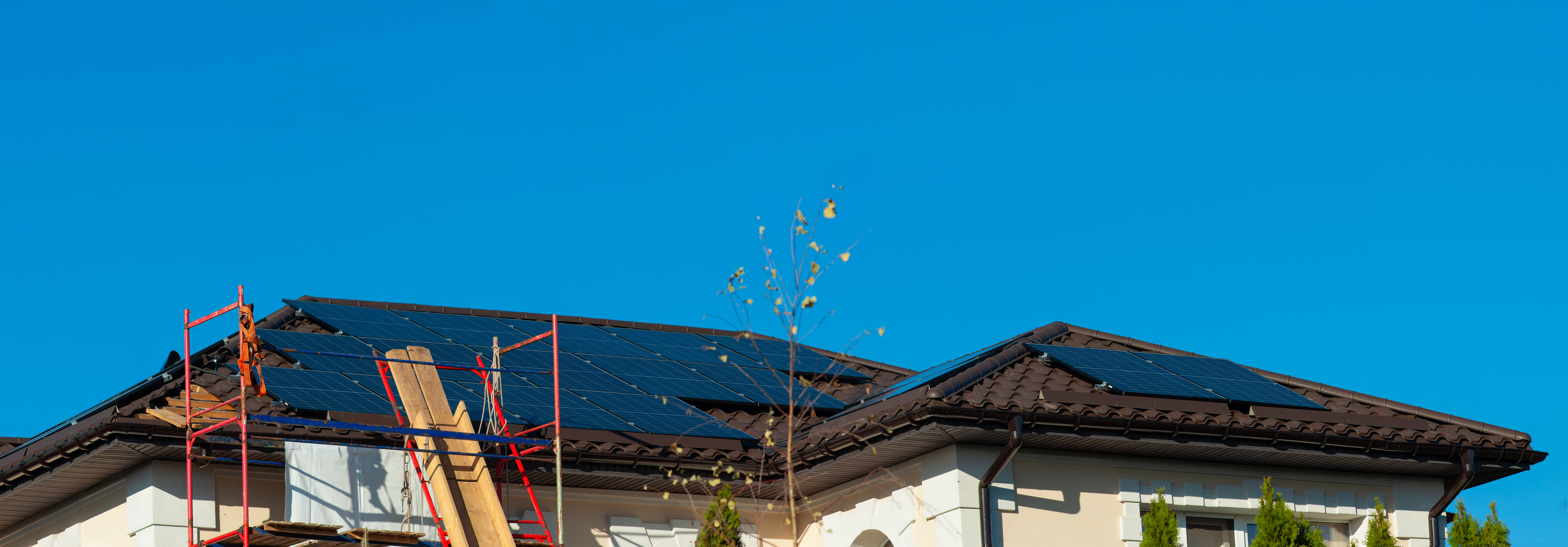 solar-panels-being-installed-tiled-roof-with-scaffolding-place-clear-skies